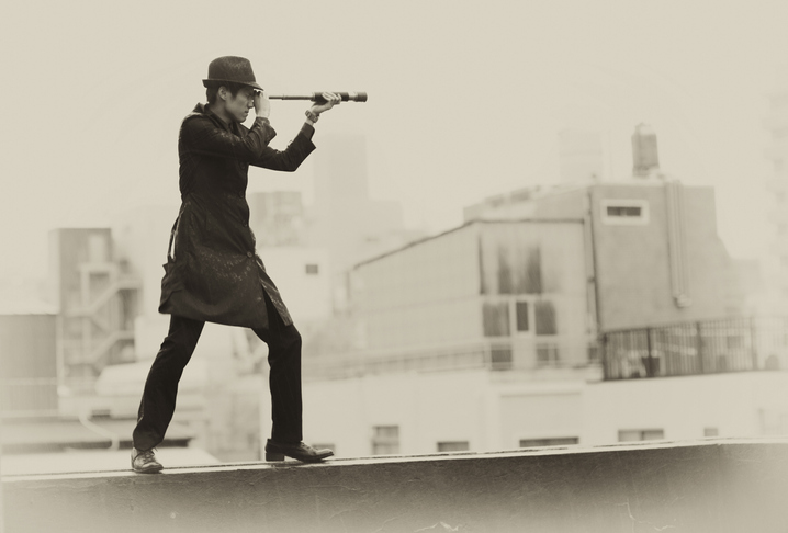 Private Investigator on a rooftop looking through a spyglass