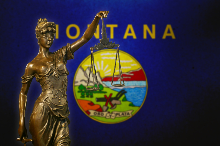 Lady Justice before a flag of Montana